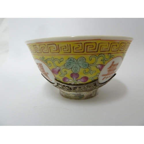 149 - A Chinese porcelain white metal mounted cup and saucer, the porcelain teabowl decorated with good fo... 