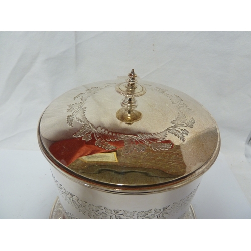 3 - A silver plated biscuit box, circular on bun feet and with hinged cover, decorated with floral garla... 