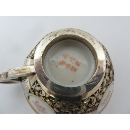 78 - A Chinese porcelain white metal mounted cup and saucer, the porcelain teabowl decorated with good fo... 