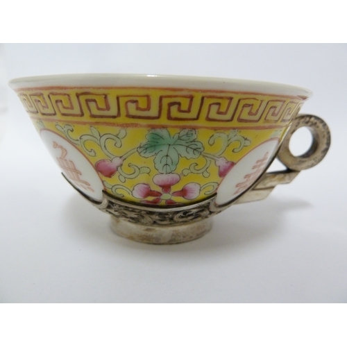 78 - A Chinese porcelain white metal mounted cup and saucer, the porcelain teabowl decorated with good fo... 