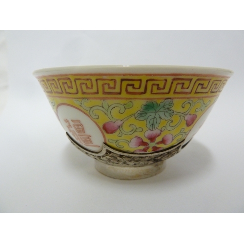 78 - A Chinese porcelain white metal mounted cup and saucer, the porcelain teabowl decorated with good fo... 