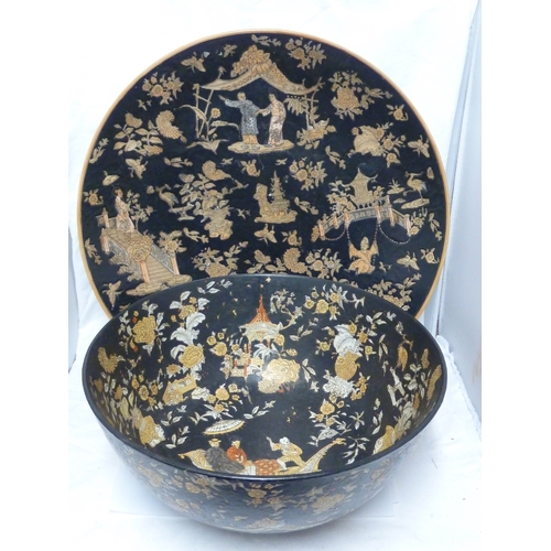 61 - A Chinese porcelain punch bowl; and a charger similar, each decorated with figures on a famille noir... 