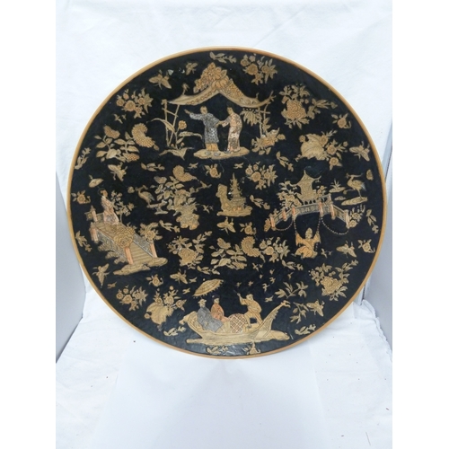 61 - A Chinese porcelain punch bowl; and a charger similar, each decorated with figures on a famille noir... 