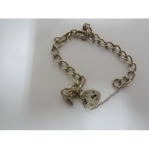 18 - A silver bracelet with heart form padlock clasp; a stick pin modelled as a horse head and riding cro... 