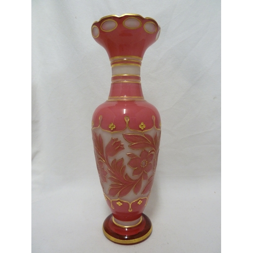 93 - A Bohemian glass vase, of bright pink cut through to opaque white with a band of scrolling flowers a... 