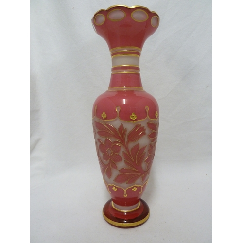 93 - A Bohemian glass vase, of bright pink cut through to opaque white with a band of scrolling flowers a... 