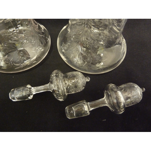 176 - Stevens and Williams - a pair of intaglio cut glass decanters, bell form with acorn form stoppers cu... 