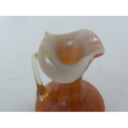 102 - Loetz - a miniature glass ewer, of mottled orange colour with iridescent yellow angular handle, 7.5c... 