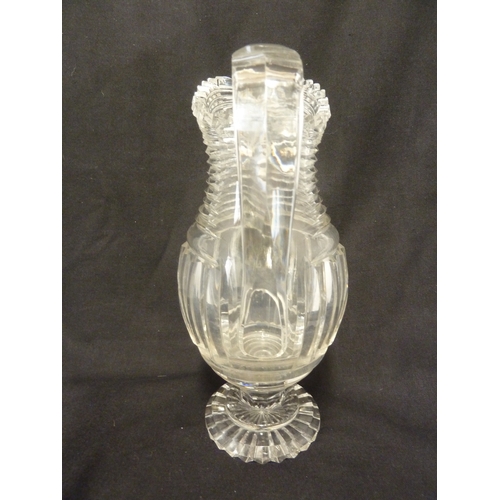 199 - A Georgian step glass cut water jug, of fluted body and applied strap handle, 21cm high