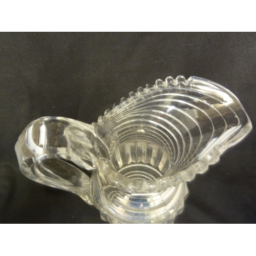 199 - A Georgian step glass cut water jug, of fluted body and applied strap handle, 21cm high