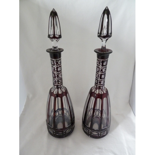 98 - Bohemian glass, a large pair of mallet form decanters of deep ruby overlay cut through to colourless... 