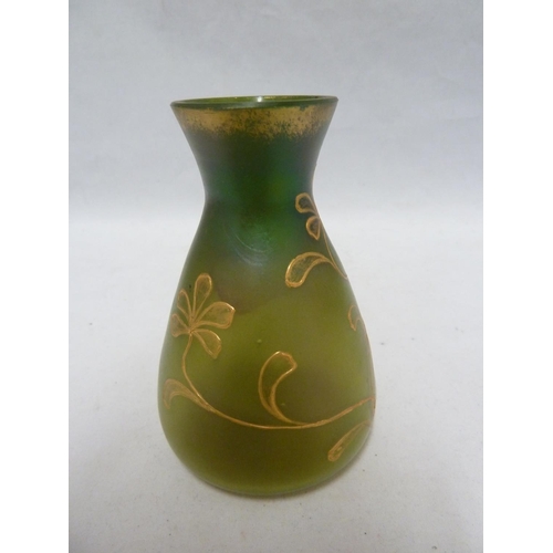 107 - Loetz - An iridescent green glass vase of flask form, tube lined and gilded with a flowering vine, 1... 