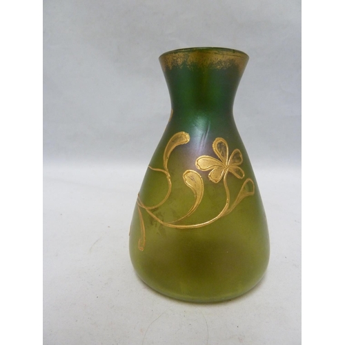 107 - Loetz - An iridescent green glass vase of flask form, tube lined and gilded with a flowering vine, 1... 