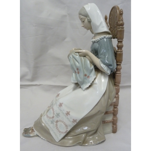 61 - A Lladro porcelain figure, The Embroiderer, modelled as a woman seated in a high backed chair and em... 