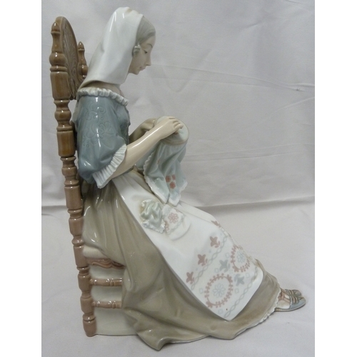 61 - A Lladro porcelain figure, The Embroiderer, modelled as a woman seated in a high backed chair and em... 