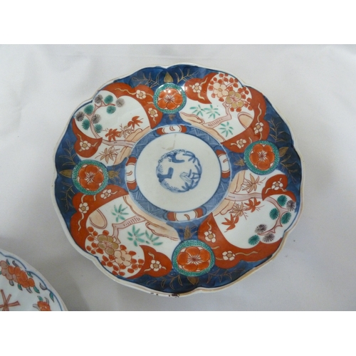 71 - Two Japanese Imari porcelain plates, with scalloped edge and painted in blue with floral sprays to t... 