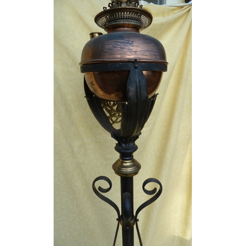 126 - An Arts and Crafts wrought iron and copper telescopic standard oil lamp, in the style of W A S Benso... 