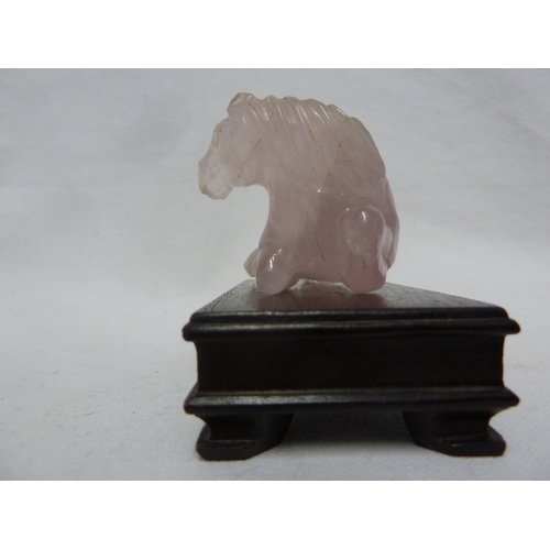 47 - A Chinese carved rose quartz figure of a horse; and wooden stand (2)