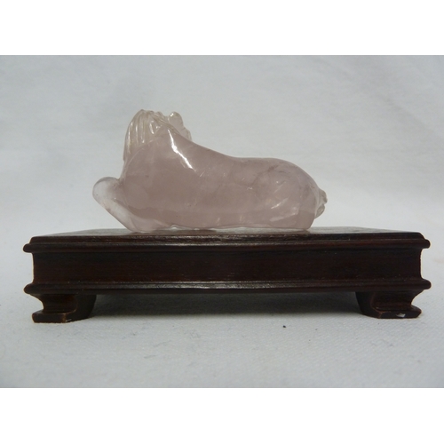 47 - A Chinese carved rose quartz figure of a horse; and wooden stand (2)