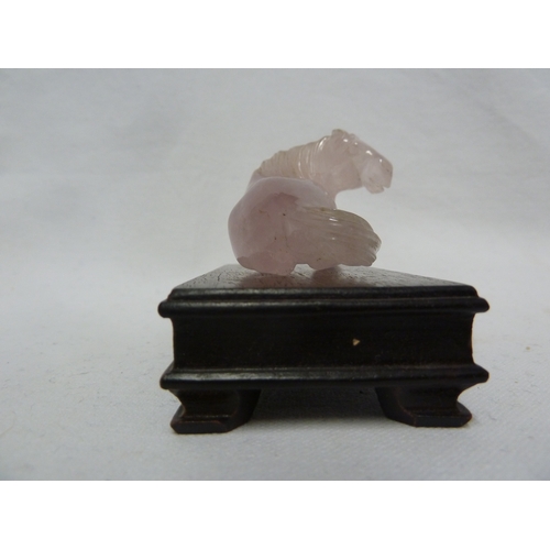 47 - A Chinese carved rose quartz figure of a horse; and wooden stand (2)