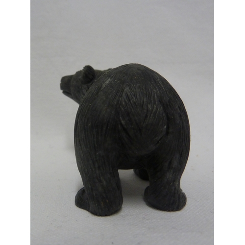 44 - A carved coal figure of a bear, with applied glass eyes, 9 cm max.