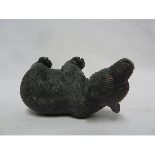 44 - A carved coal figure of a bear, with applied glass eyes, 9 cm max.