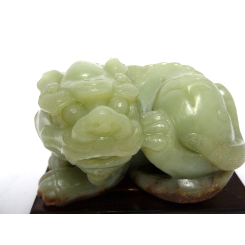 42 - A large Chinese Celedon jade figure of a Kylin, 12.5cm max; and a wooden stand (2)