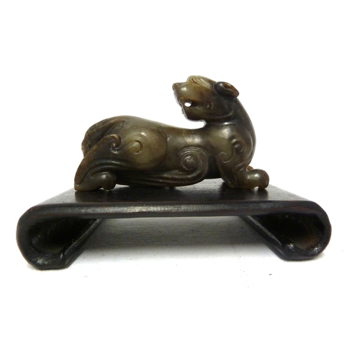 41 - A Chinese olive green jade Kylin, modelled crouching with head turned backwards, 7.5cm max; and a wo... 