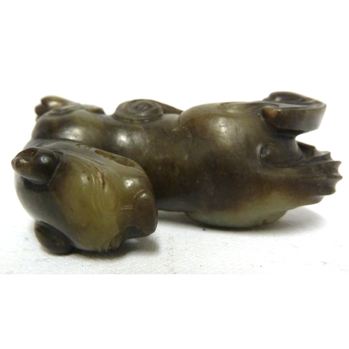 41 - A Chinese olive green jade Kylin, modelled crouching with head turned backwards, 7.5cm max; and a wo... 