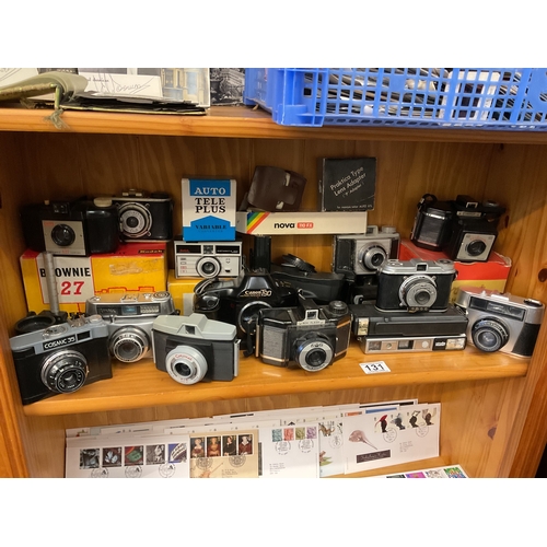 131 - A shelf of vintage cameras