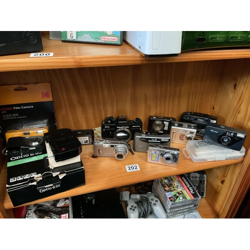 202 - Shelf of digital and other cameras