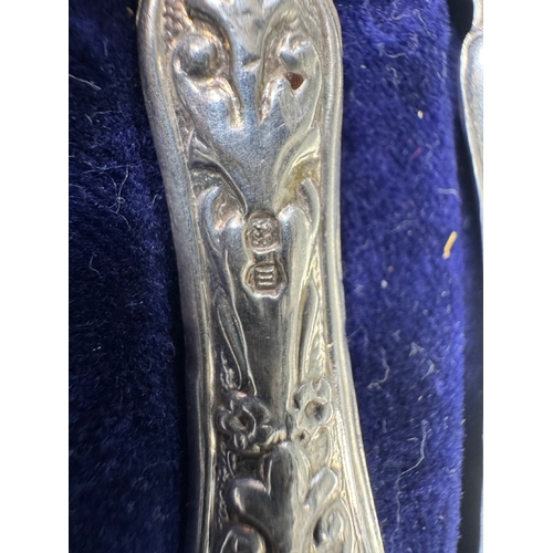 35 - Cased set of six ornate silver‑handled table knives, fitted case — 149g.

Heavily embossed silver ha... 