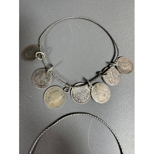 34 - Mixed silver lot — three coin‑charm bangles, cut 1939 farthing pendant on chain and assorted silver ... 