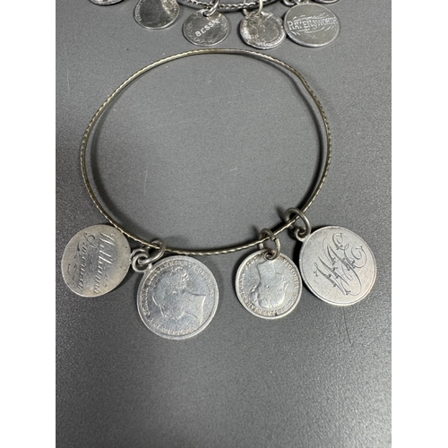 34 - Mixed silver lot — three coin‑charm bangles, cut 1939 farthing pendant on chain and assorted silver ... 