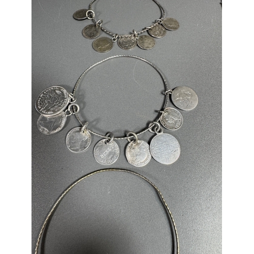 34 - Mixed silver lot — three coin‑charm bangles, cut 1939 farthing pendant on chain and assorted silver ... 