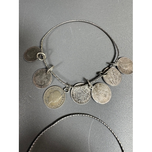 34 - Mixed silver lot — three coin‑charm bangles, cut 1939 farthing pendant on chain and assorted silver ... 