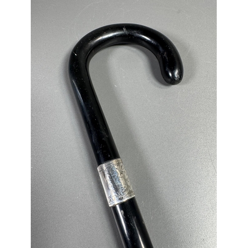 28 - Ebonised walking cane with engraved silver collar & cap, brass ferrule — approx. 95cm.

Ebonised can... 