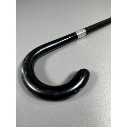 28 - Ebonised walking cane with engraved silver collar & cap, brass ferrule — approx. 95cm.

Ebonised can... 