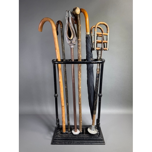 Victorian cast iron umbrella/stick stand with drip tray, plus mixed vintage walking sticks and umbrellas, wooden handles, decorative hall stand.

Keywords: umbrella stand, stick stand, Victorian, cast iron, walking sticks, canes, hall stand, vintage decor, umbrella rack, antique furniture  Shipping available: UK only preferred (heavy), or courier arranged.