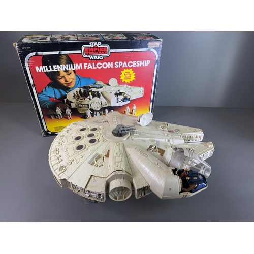 Palitoy Star Wars The Empire Strikes Back 33364 Millennium Falcon Spaceship with Original Box. 

A collection of three items comprising a vintage vehicle and two loose action figures by Palitoy and Kenner, United Kingdom and USA, circa 1979. The lot comprises:

A Millennium Falcon Spaceship constructed from moulded off-white plastic with applied paper and foil detailing. The underside of the ship features an embossed circular mark reading © CPG PRODUCTS 1979 / KENNER PRODUCTS Div. / Cincinnati, Ohio 45202. The vehicle features a removable upper hull plate, an opening cockpit with clear canopy, a rotating radar dish, and a manually elevating quad-laser cannon. The interior play set contains a Dejarik space chess table, a blue seating pod, a secret floor compartment, and a training remote ball suspended from a grey arm. The original printed card box is present, bearing the Palitoy logo and The Empire Strikes Back Star Wars branding. A white adhesive retail label on the box reads ROY HALL CASH & CARRY LTD / 024273 / MILLENIUM FALCON 33364 / RETAIL 28.75 / COST 16.81.

Two loose vintage action figures depicting the characters Han Solo and Chewbacca, both of plastic construction and presented without original individual packaging.