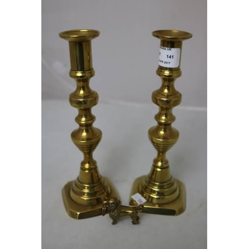 141 - A pair of brass candlesticks together with a small brass poodle curio