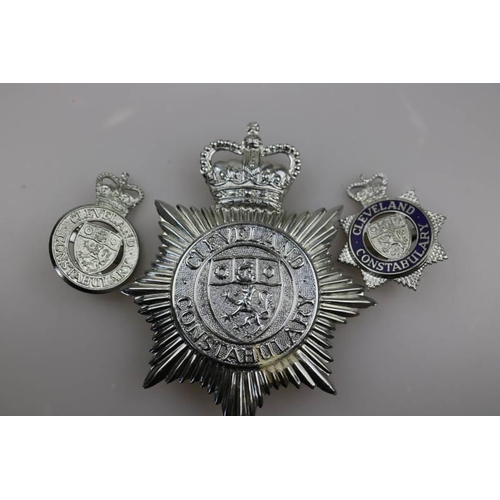 202 - An obsolete Cleveland Constabulary helmet badge together with obsolete Cleveland Constabulary cap ba... 