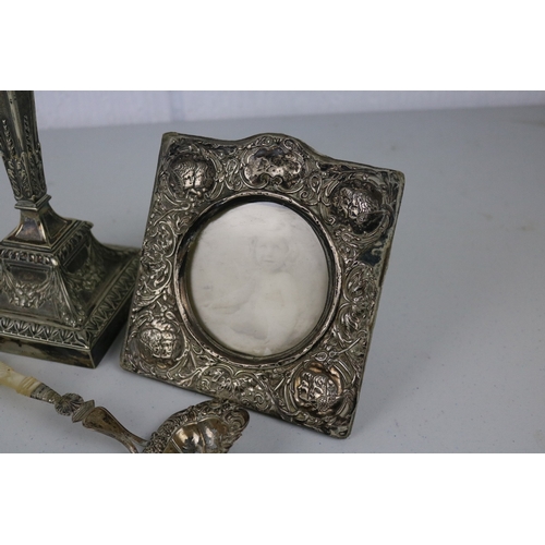 76 - Plated candlestick, Silver cherub frame and a ladle