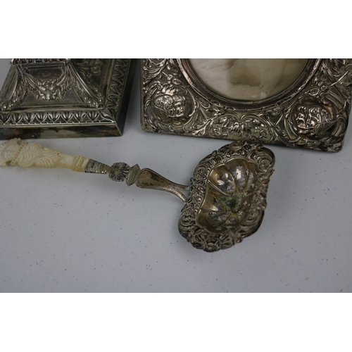 76 - Plated candlestick, Silver cherub frame and a ladle