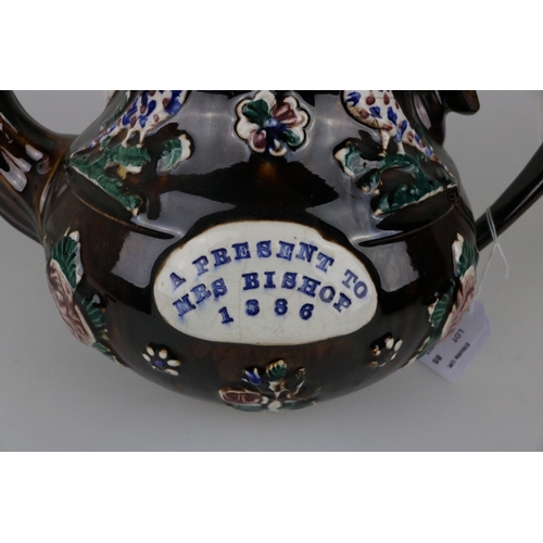 85 - An antique treacle glaze barge ware teapot with message to the front 