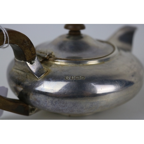 105 - A silver teapot with wooden handle