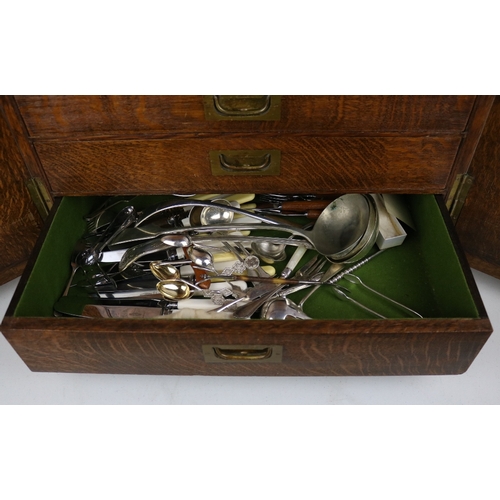 215 - An Oak canteen of cutlery enclosed by two doors contents as shown in images