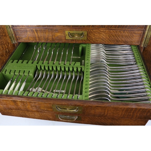 215 - An Oak canteen of cutlery enclosed by two doors contents as shown in images