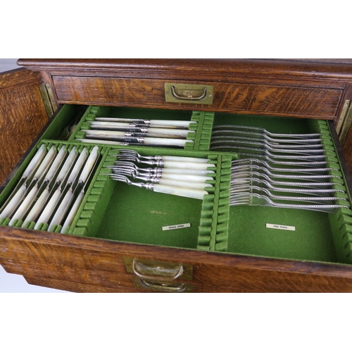 215 - An Oak canteen of cutlery enclosed by two doors contents as shown in images