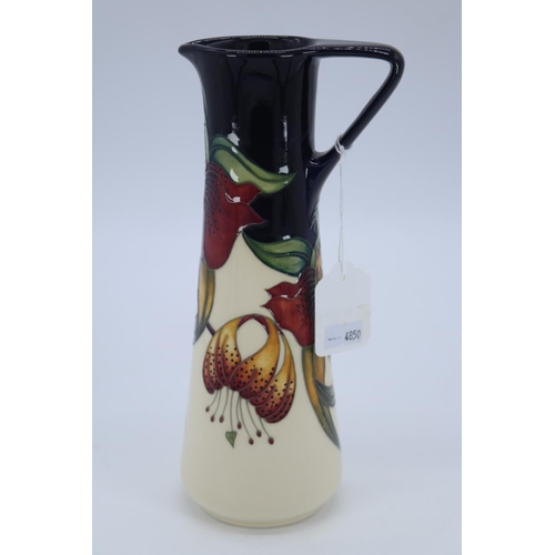 234 - Moorcroft jug in the Anna Lily design (approx 23cm tall) Impressed marks to base.